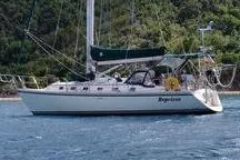 Sailboat Caliber 40LRC 1999 on water, lush green background, side view.