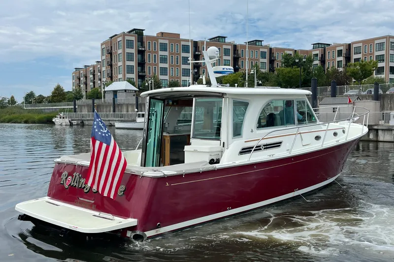 Rolling Stone Yacht Photos Pics 2017 Back Cove 41 boat with American flag, docked near modern buildings.