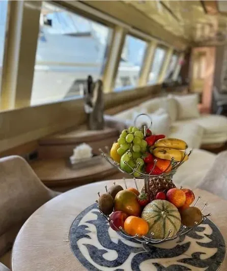  Yacht Photos Pics Luxurious Mondomarine yacht interior with fruit centerpiece, elegant seating, and large windows.
