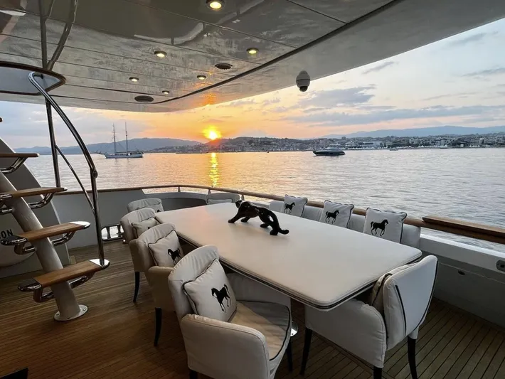  Yacht Photos Pics Luxury yacht deck with dining area, sunset view over calm waters. Mondomarine Custom, 1995.