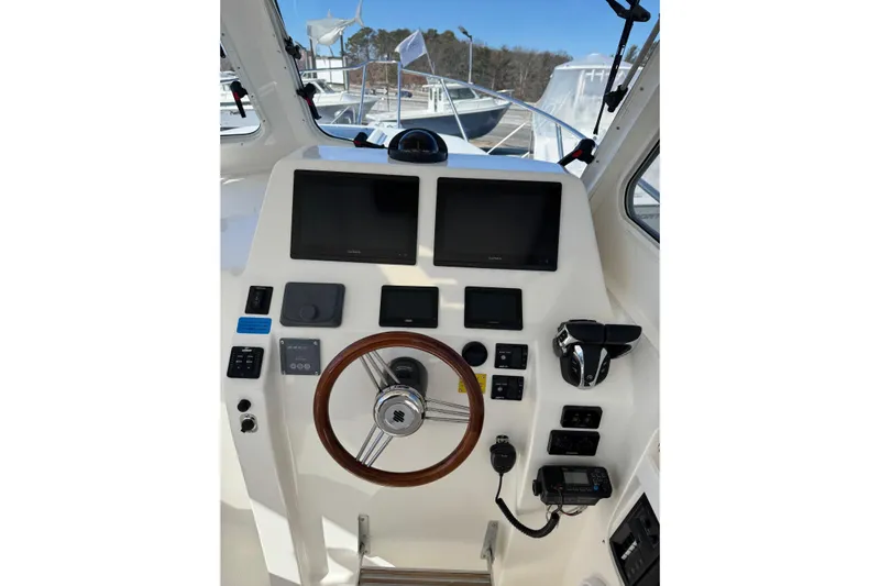  Yacht Photos Pics 2024 NorthCoast 285 HT helm with dual screens, steering wheel, and control panel.