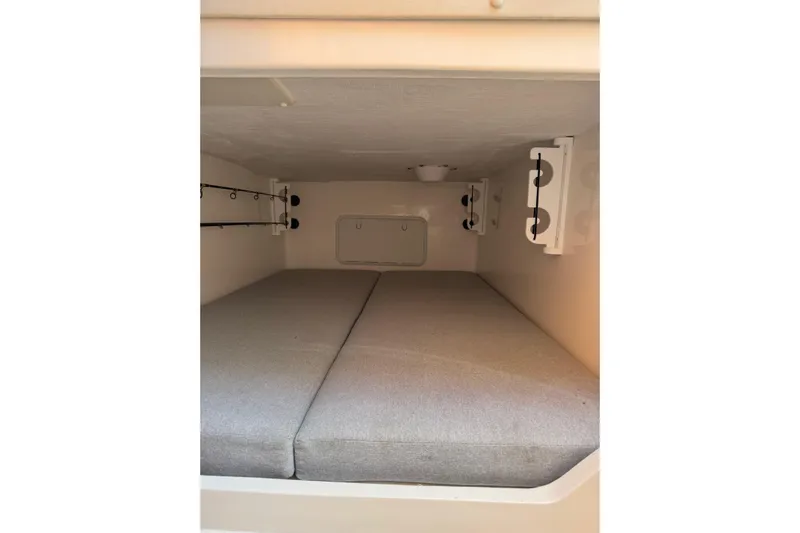  Yacht Photos Pics 2024 NorthCoast 285 HT cabin interior with cushioned sleeping area and rod holders.