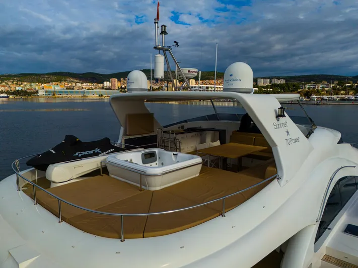 Clouds Yacht Photos Pics Luxurious 2013 Sunreef 70 Power yacht with spacious deck and jacuzzi, docked in scenic harbor.
