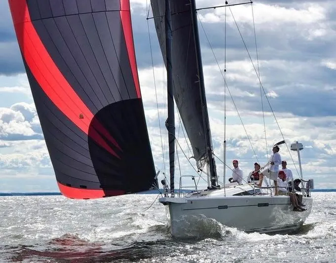 **4806tw Yacht Photos Pics 2017 Dehler 42c sailboat with vibrant sails navigating choppy waters under a cloudy sky.