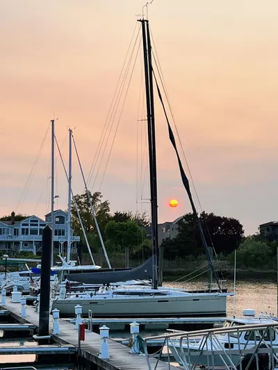 **4806tw Yacht Photos Pics 2017 Dehler 42c sailboat docked at sunset, with waterfront homes in the background.