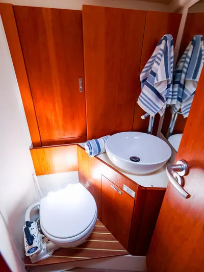 **4806tw Yacht Photos Pics 2017 Dehler 42c yacht bathroom with wooden cabinets, round sink, and striped towels.