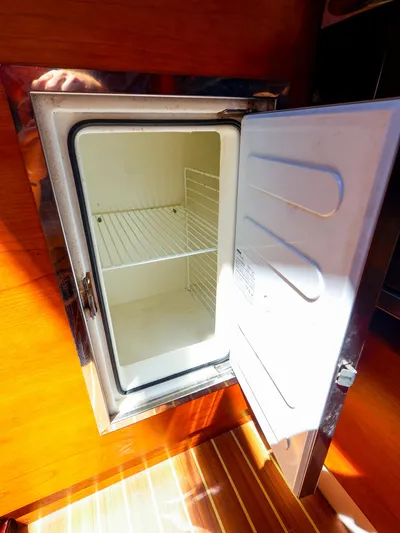 **4806tw Yacht Photos Pics Open refrigerator inside 2017 Dehler 42c yacht, showcasing empty shelves and wooden interior.