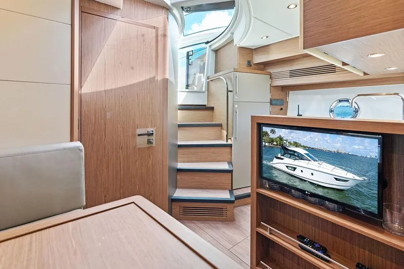 Two Segals Yacht Photos Pics Interior of 2019 Beneteau Gran Turismo 46 yacht with modern wood finish and TV display.