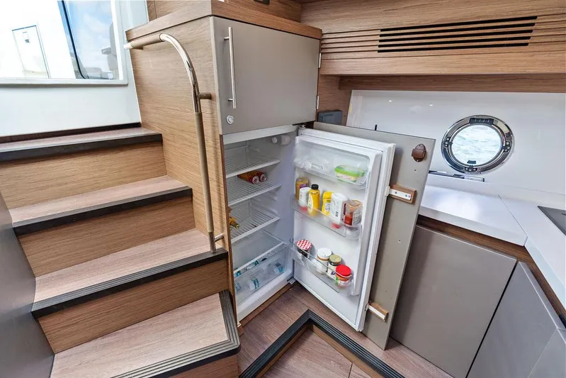 Two Segals Yacht Photos Pics Interior of 2019 Beneteau Gran Turismo 46 yacht with open fridge and wooden stairs.