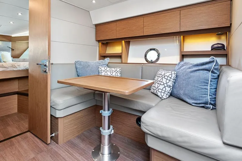 Two Segals Yacht Photos Pics 2019 Beneteau Gran Turismo 46 interior with cozy seating and wooden table.