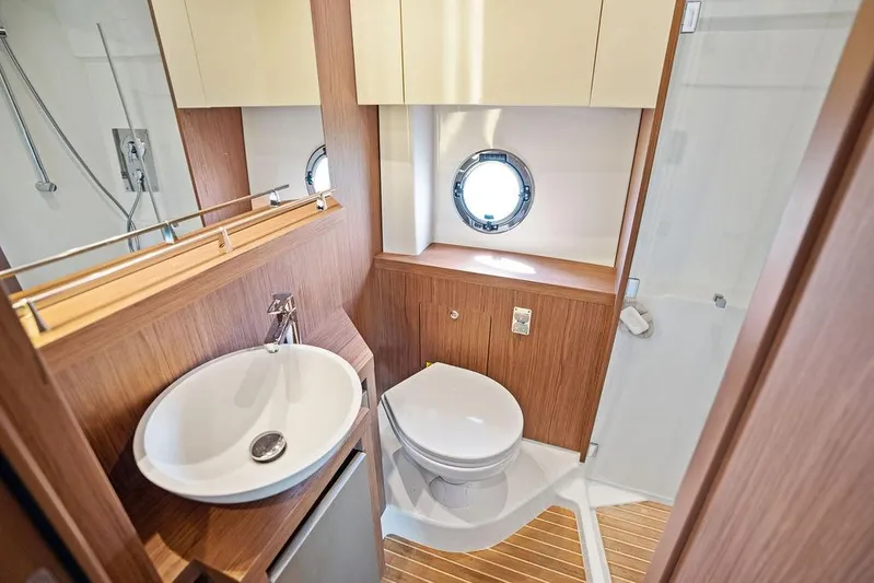 Two Segals Yacht Photos Pics Luxurious bathroom in 2019 Beneteau Gran Turismo 46 yacht with modern fixtures and wood accents.