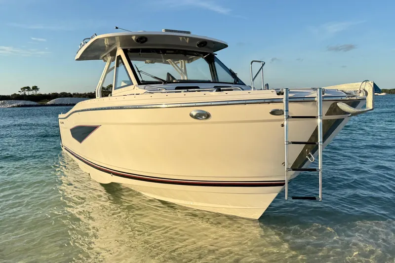  Yacht Photos Pics 2025 Solara S-310 CW boat anchored in clear, shallow water under a blue sky.
