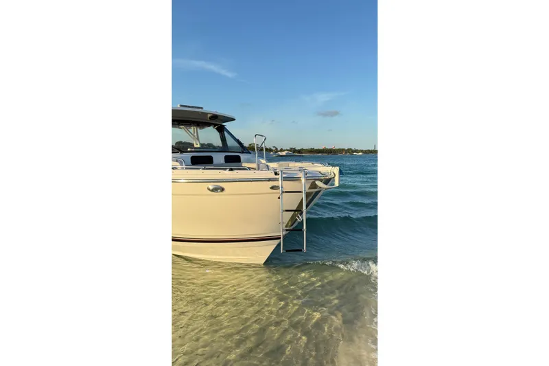  Yacht Photos Pics 2025 Solara S-310 CW boat docked on clear water with ladder extended.