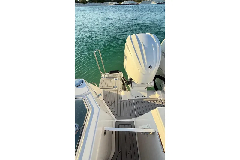  Yacht Photos Pics 2025 Solara S-310 CW boat deck with outboard motor on calm water.