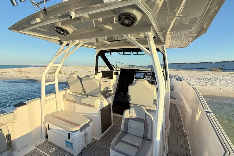  Yacht Photos Pics 2025 Solara S-310 CW boat interior with seating, console, and beach backdrop.