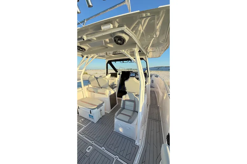  Yacht Photos Pics 2025 Solara S-310 CW boat interior with seating and helm, docked by the shore.
