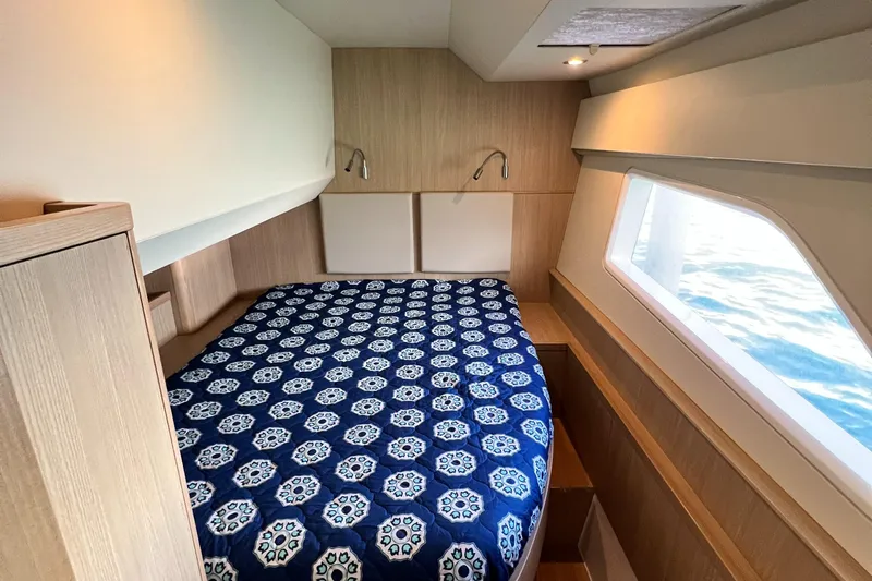 Gr8 Day Yacht Photos Pics Cozy bedroom in 2018 Aquila 44 Yacht with patterned blue bedspread and ocean view.