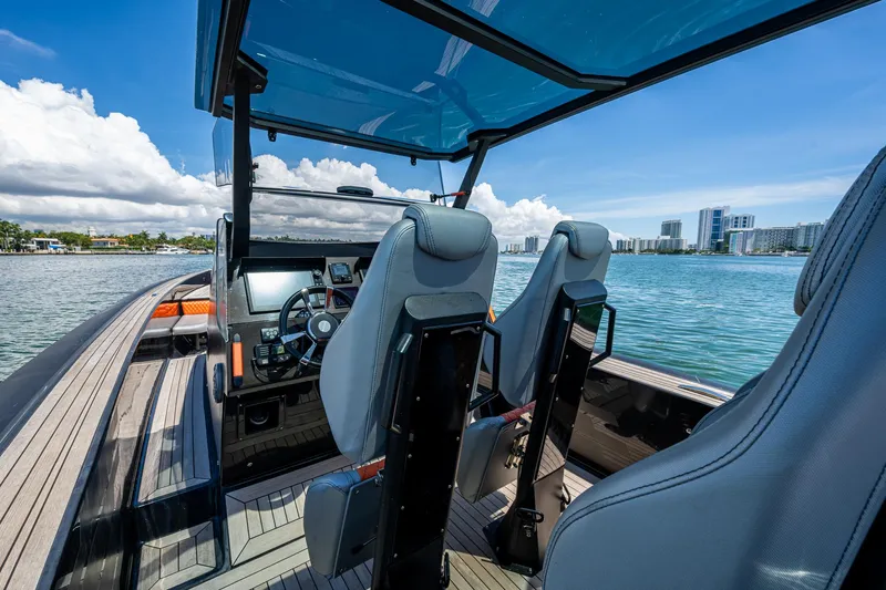 Fightertown Yacht Photos Pics 2019 Technohull OMEGA 45 boat interior with modern dashboard and seating, overlooking a scenic waterfront.