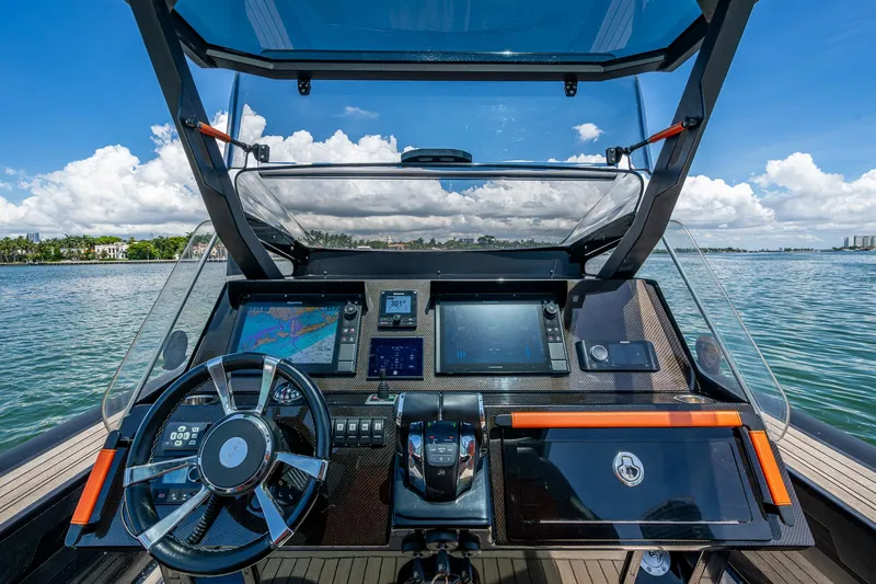 Fightertown Yacht Photos Pics 2019 Technohull OMEGA 45 dashboard with navigation screens and steering wheel on open water.