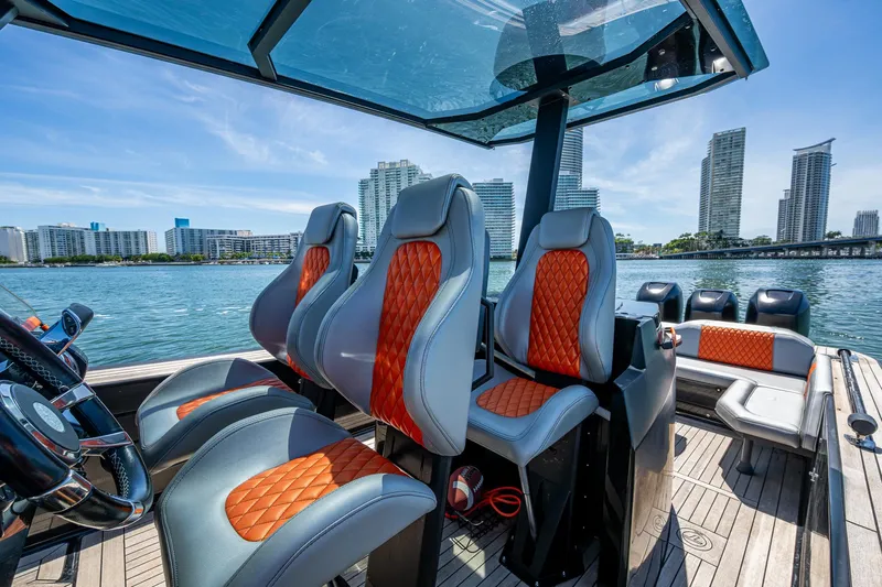 Fightertown Yacht Photos Pics Luxurious 2019 Technohull OMEGA 45 boat interior with stylish seating, city skyline in background.
