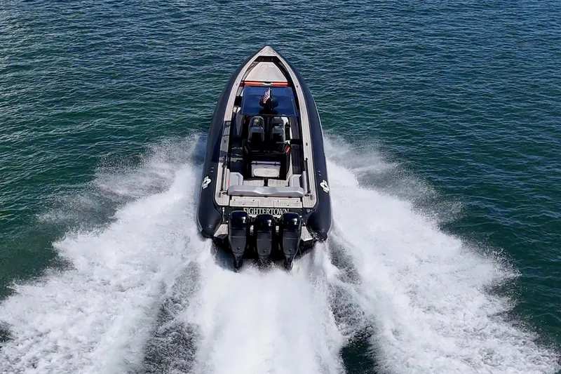 Fightertown Yacht Photos Pics 2019 Technohull OMEGA 45 speedboat cruising on open water, rear view.