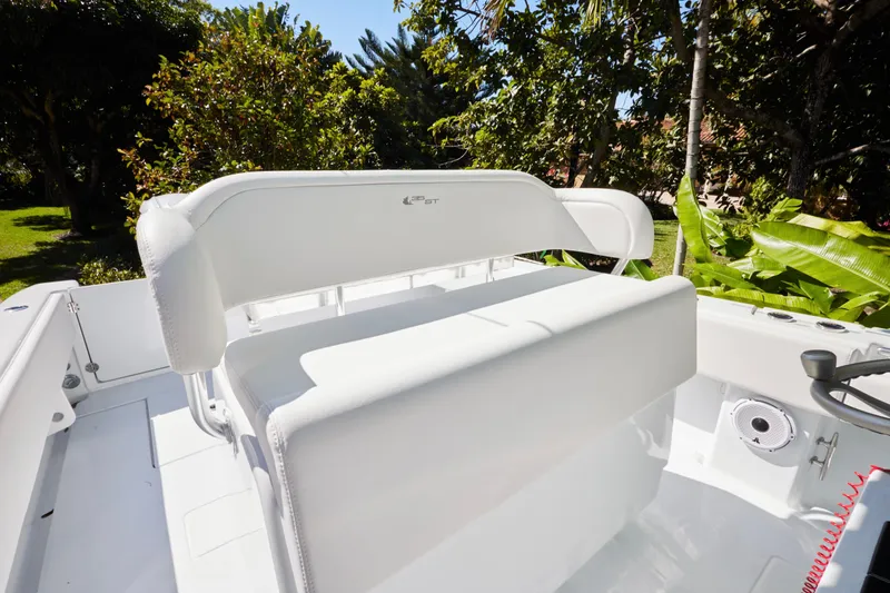  Yacht Photos Pics 2024 Contender 35 ST boat interior with white seating, surrounded by lush greenery.