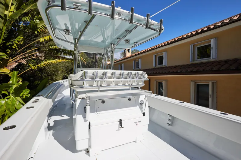  Yacht Photos Pics 2024 Contender 35 ST boat with T-top, rod holders, and sleek design near a house.