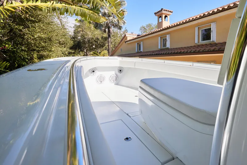  Yacht Photos Pics 2024 Contender 35 ST boat interior with seating, surrounded by lush greenery and a house.