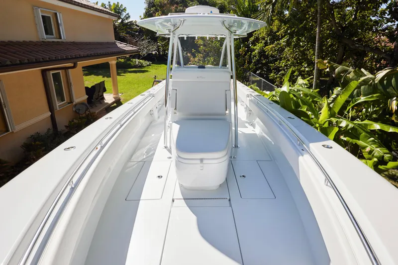  Yacht Photos Pics 2024 Contender 35 ST boat with sleek white deck, surrounded by lush greenery.