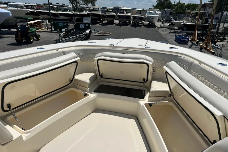  Yacht Photos Pics 2026 Scout 357 LXF boat with open storage compartments, docked at a marina.