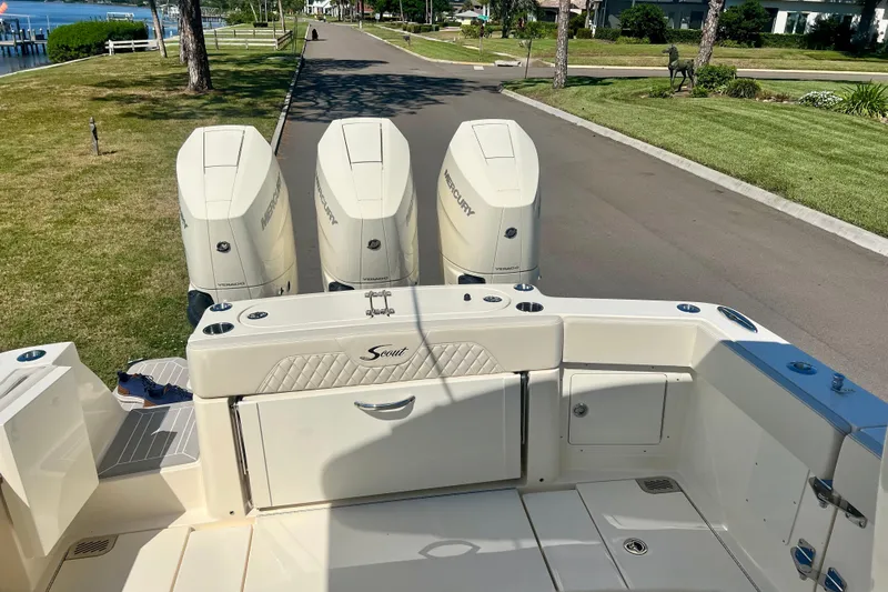  Yacht Photos Pics 2026 Scout 357 LXF boat with triple Mercury engines, parked on a scenic road.