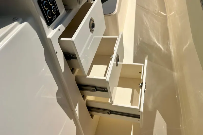  Yacht Photos Pics Open storage drawers on a 2026 Scout 357 LXF boat, showcasing interior design.
