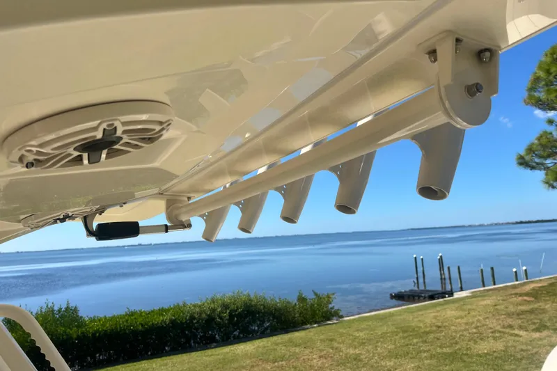  Yacht Photos Pics 2026 Scout 357 LXF boat detail with rod holders and speaker, overlooking serene waterfront.