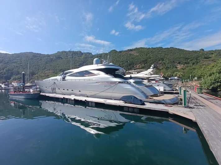 Gamma Yacht Photos Pics Luxury 2007 Pershing 115 yacht docked in scenic marina with lush hills.