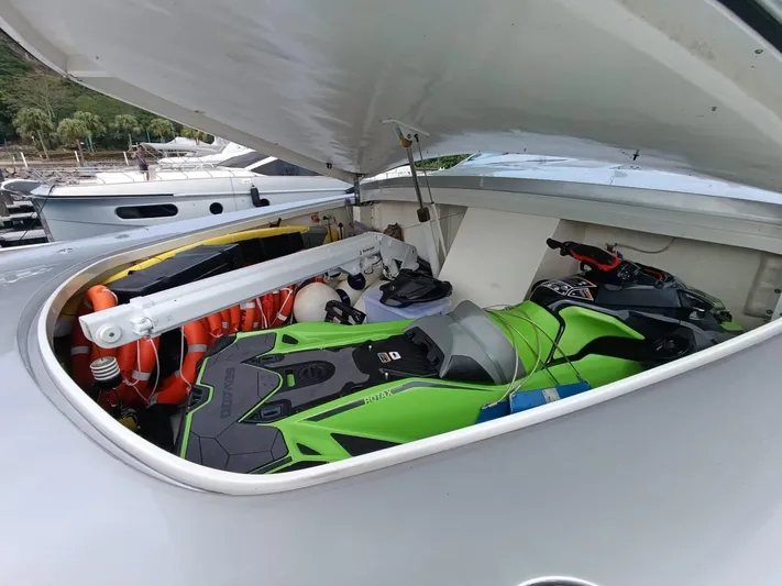 Gamma Yacht Photos Pics Storage compartment of 2007 Pershing 115 yacht with green jet ski and safety equipment.