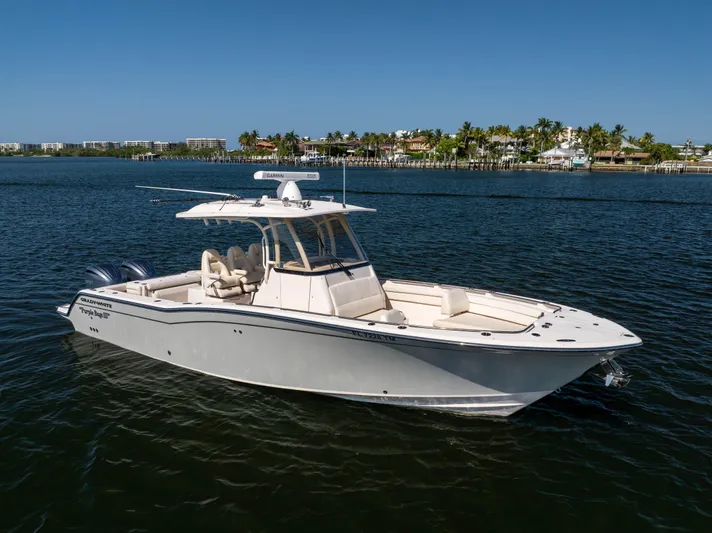 Purple Bags 2 Yacht Photos Pics 2023 Grady-White Canyon 326 boat on calm water, clear sky background.