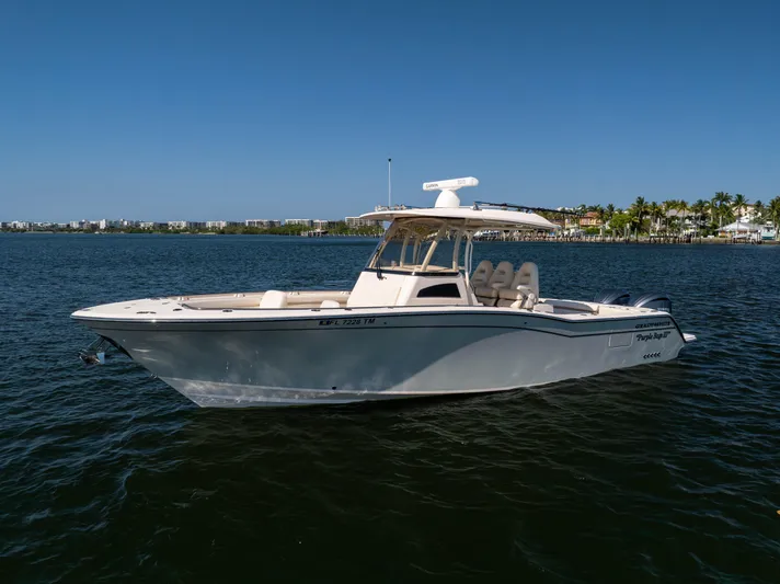 Purple Bags 2 Yacht Photos Pics 2023 Grady-White Canyon 326 boat on calm water, clear sky background.
