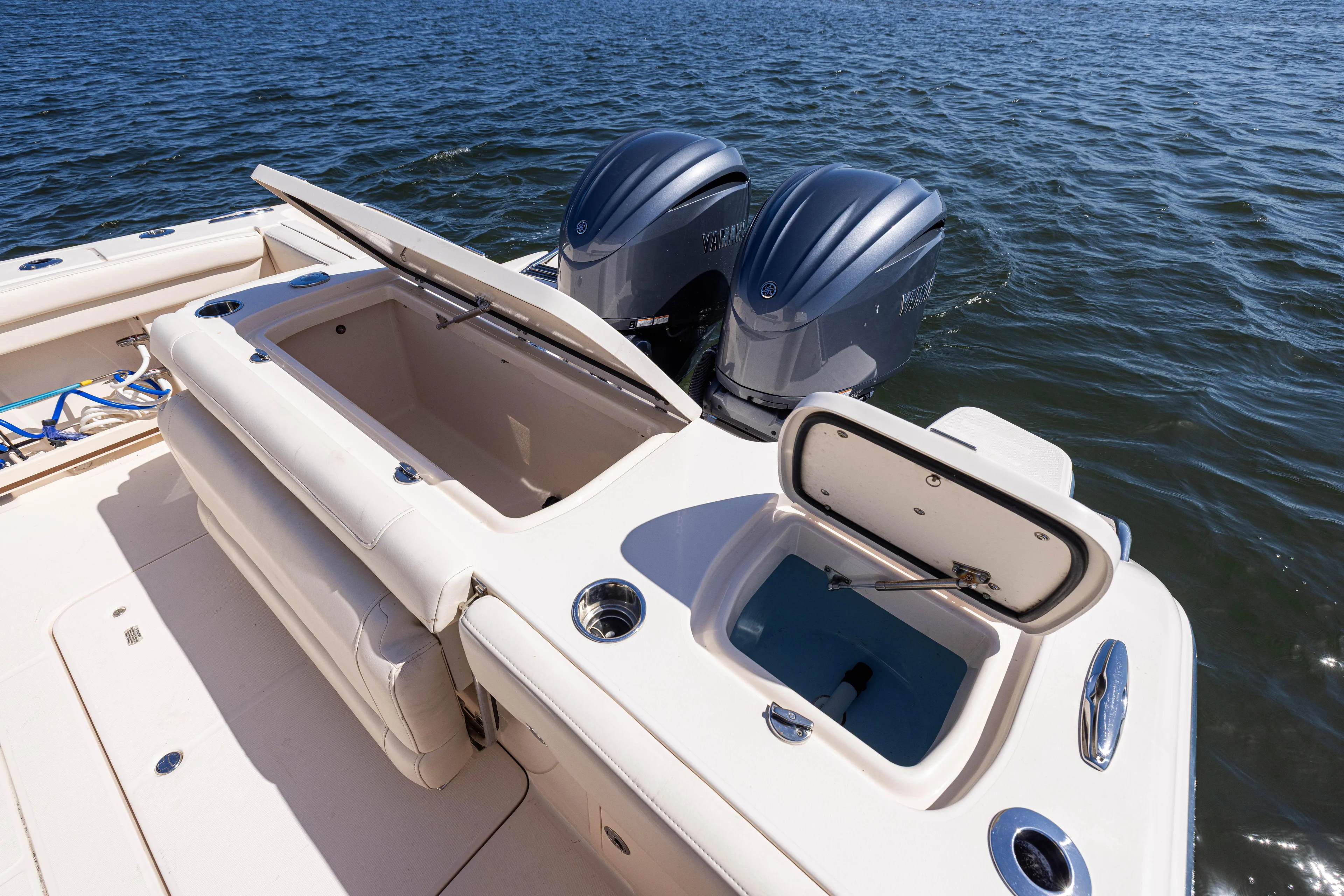 Purple Bags 2 Yacht Photos Pics 2023 Grady-White Canyon 326 boat with open storage compartments and twin engines on the water.