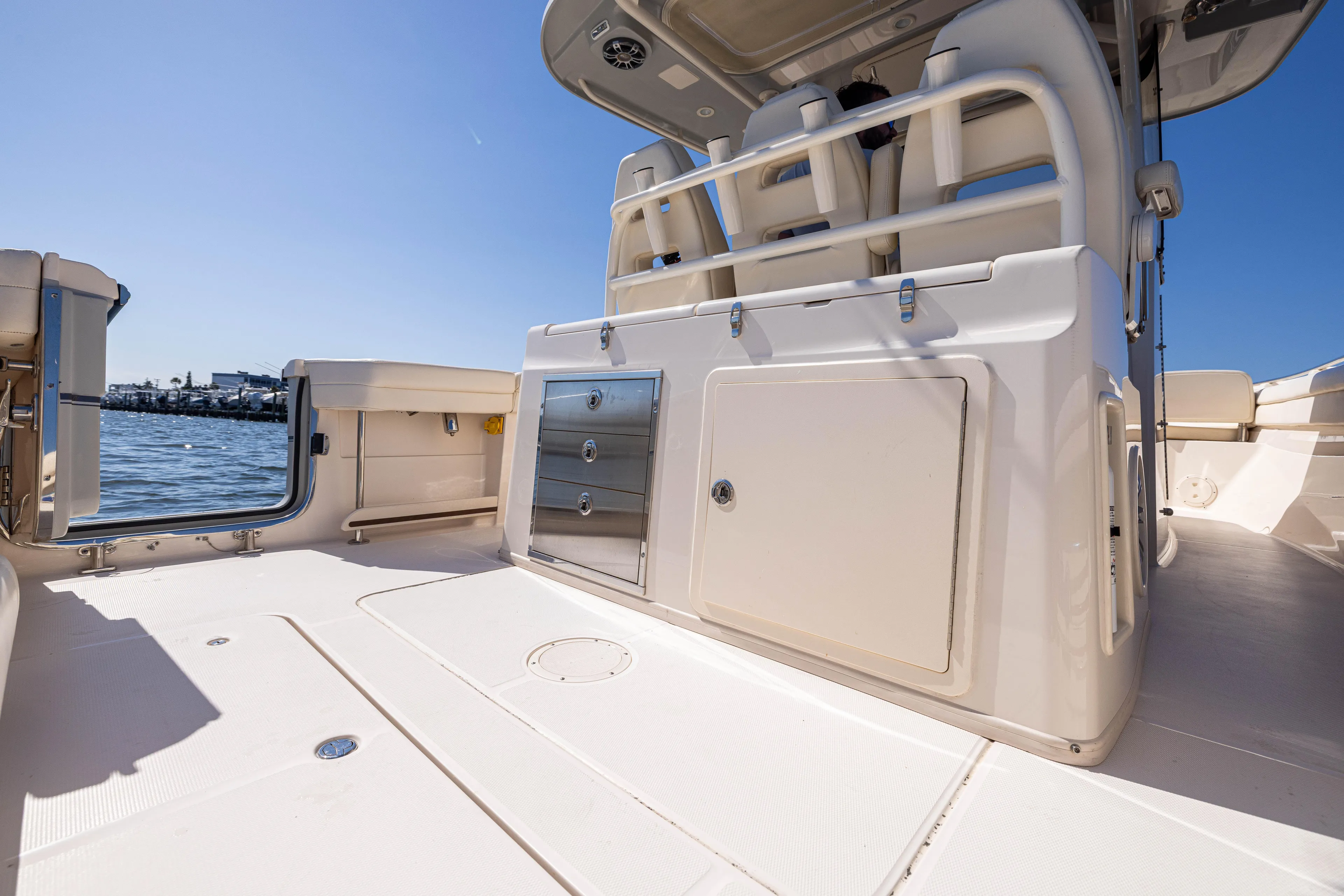 Purple Bags 2 Yacht Photos Pics 2023 Grady-White Canyon 326 boat deck with seating and storage, under clear blue sky.