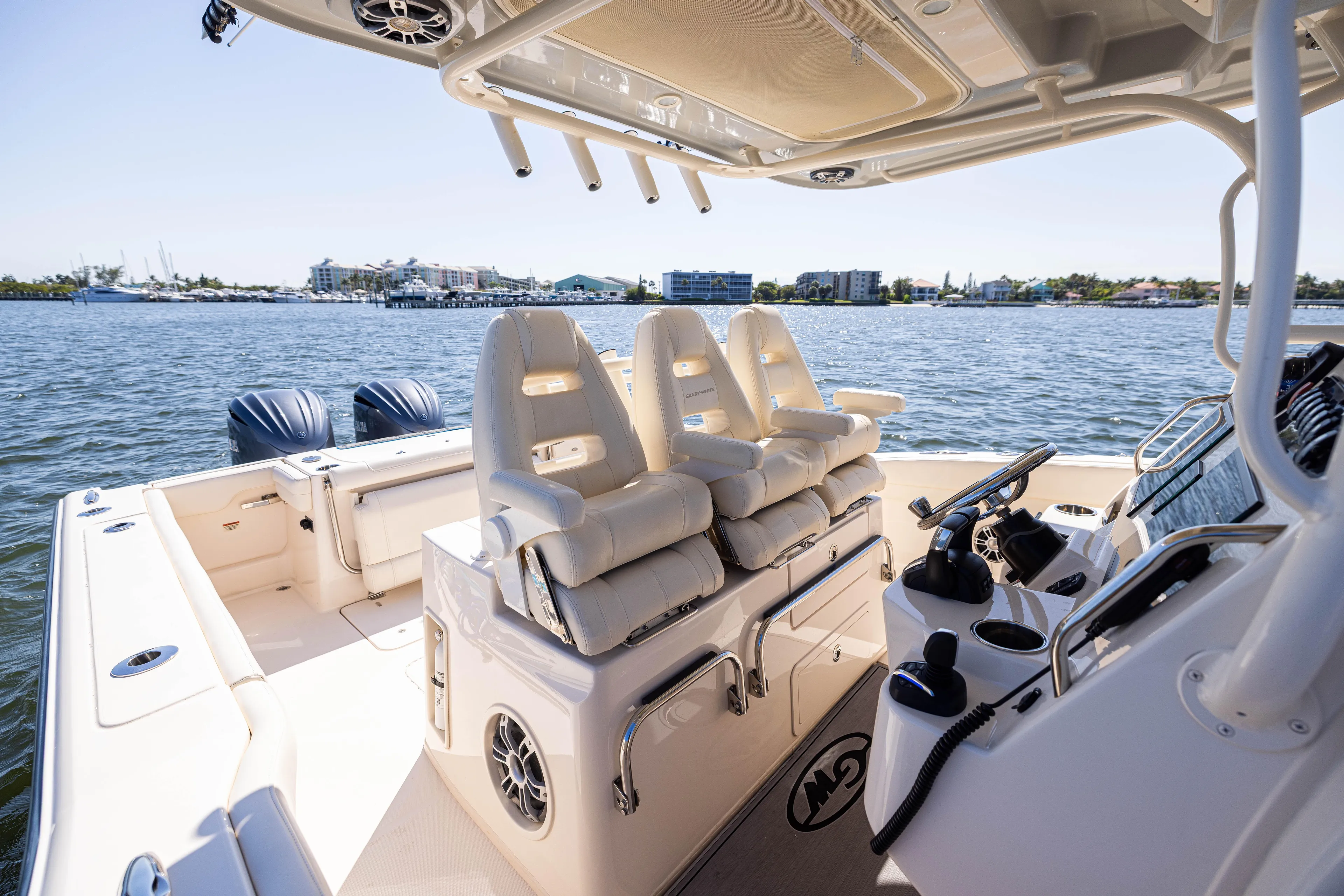Purple Bags 2 Yacht Photos Pics 2023 Grady-White Canyon 326 boat interior with seating and controls, on a sunny day.