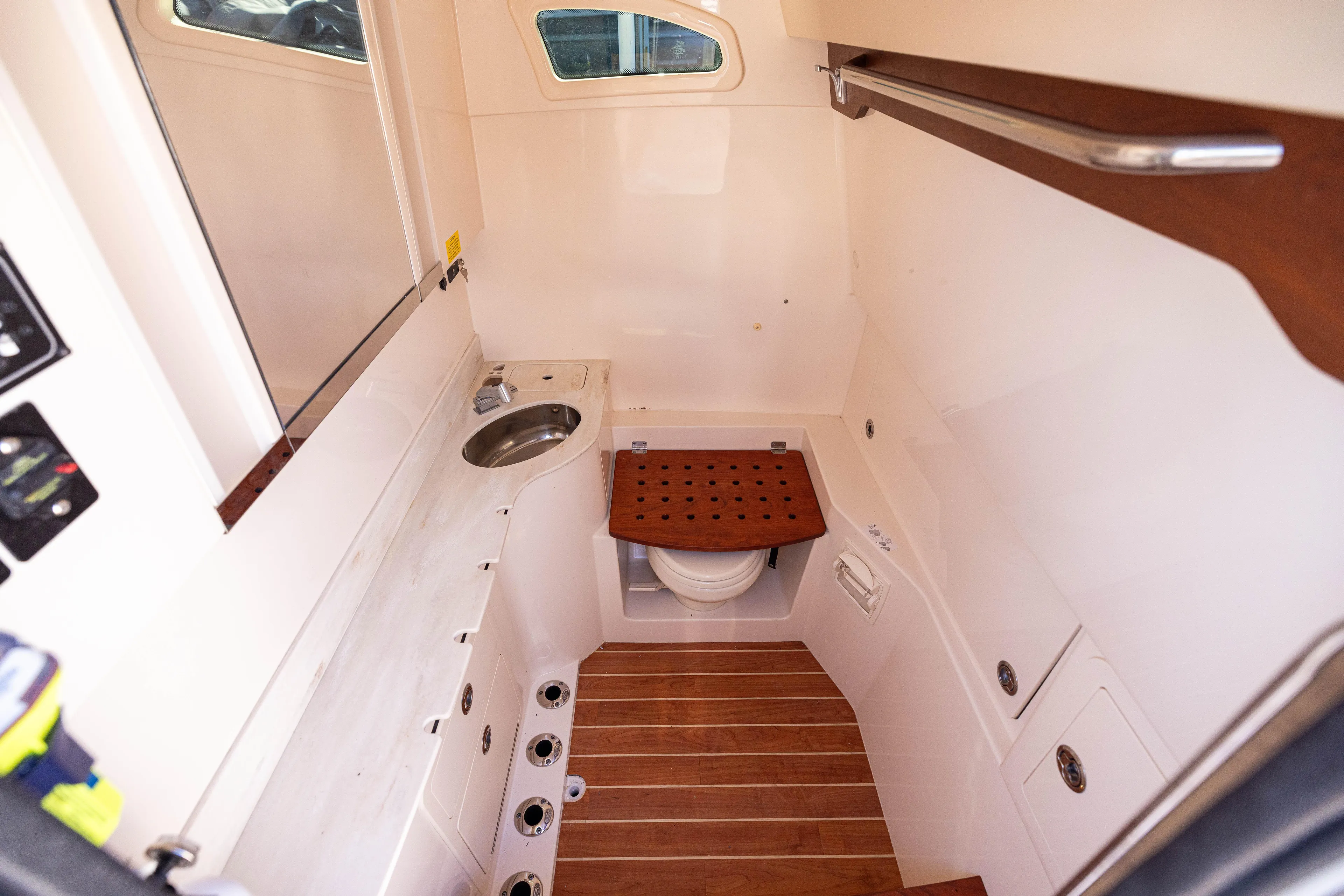 Purple Bags 2 Yacht Photos Pics 2023 Grady-White Canyon 326 boat interior with sink, toilet, and wooden flooring.