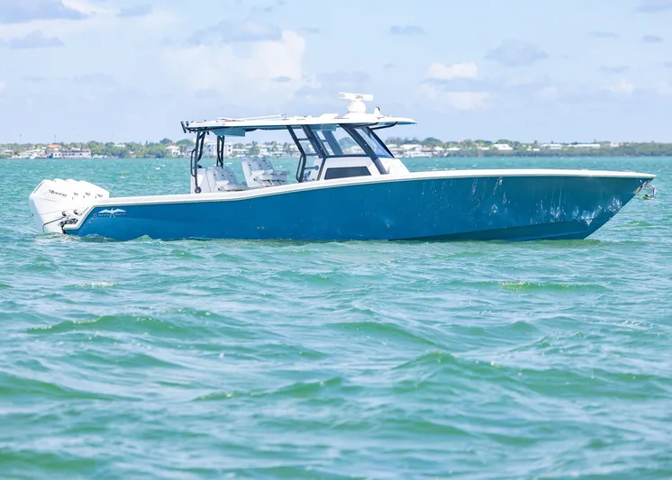 Yacht Photos Pics 2025 Invincible 43 Open Fisherman boat on calm waters, side view.