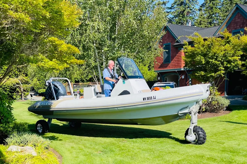  Yacht Photos Pics 2022 Sealegs 7.5M amphibious boat on grass, near a house and trees.
