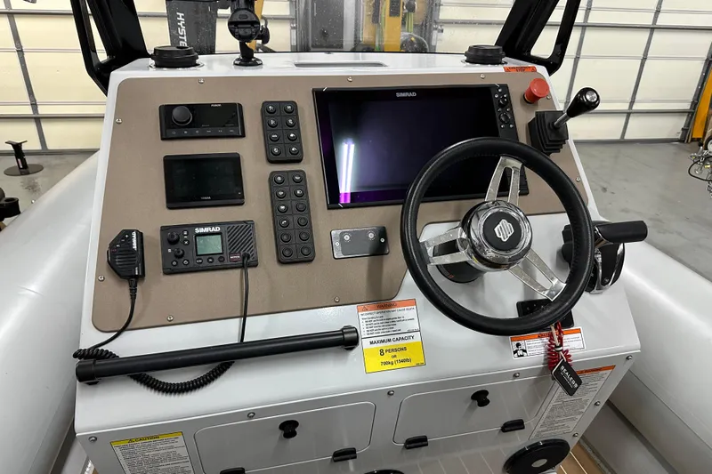  Yacht Photos Pics Control panel of a 2022 Sealegs 7.5M boat with steering wheel and navigation equipment.