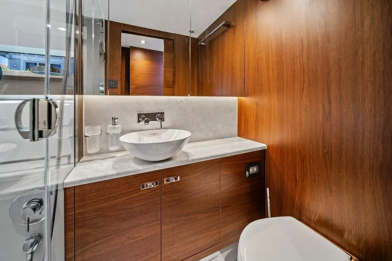 R&r Yacht Photos Pics Luxurious bathroom in 2023 Princess F50 yacht with wood paneling and modern fixtures.