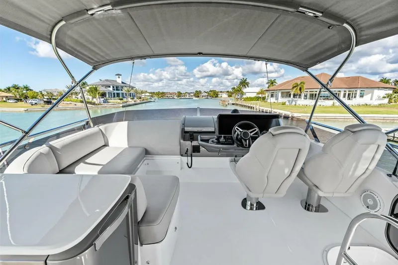 R&r Yacht Photos Pics Luxurious 2023 Princess F50 yacht interior with modern seating and steering, docked by waterfront homes.