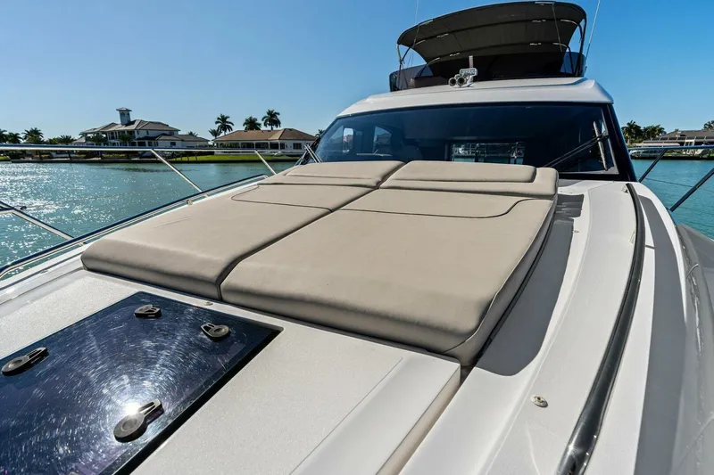 R&r Yacht Photos Pics 2023 Princess F50 yacht with sunbed, docked near waterfront homes.