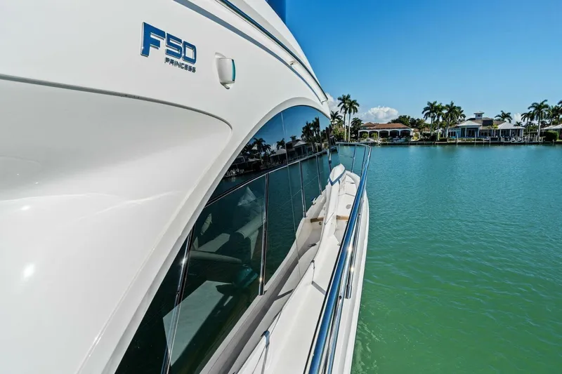 R&r Yacht Photos Pics 2023 Princess F50 yacht on serene water with luxury waterfront homes.