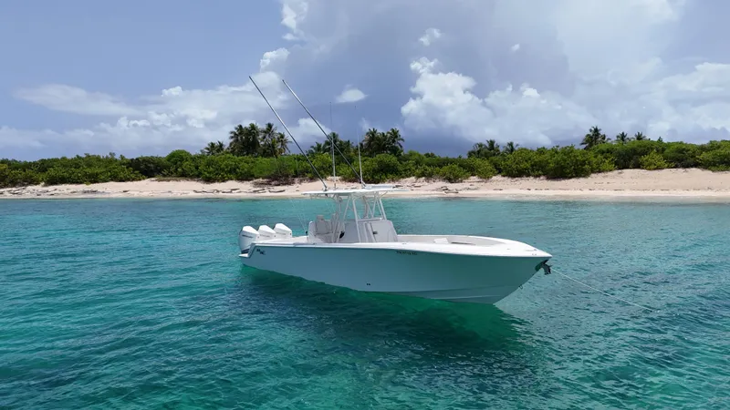  Yacht Photos Pics 2024 SeaVee 340Z boat in turquoise waters near a sandy beach with lush greenery.