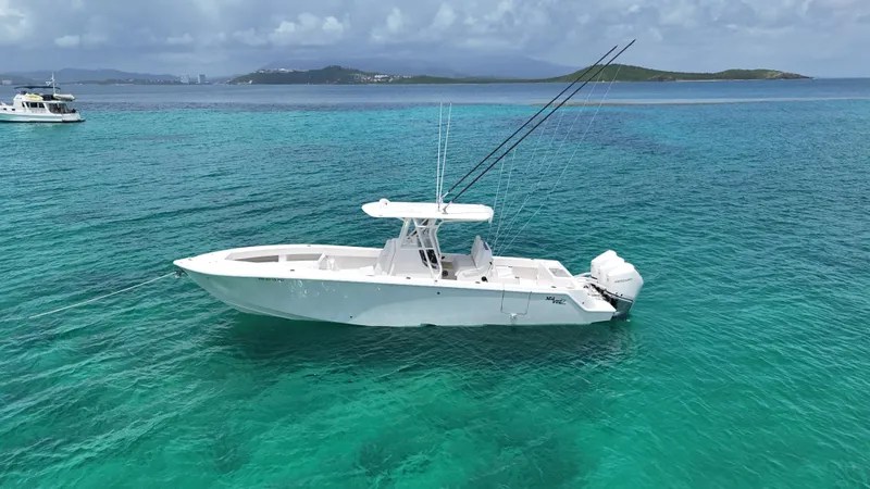  Yacht Photos Pics 2024 SeaVee 340Z boat anchored in clear turquoise water, with distant islands in the background.